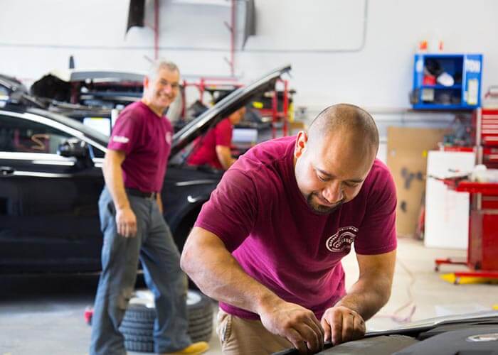 mechanics in garage working on cars